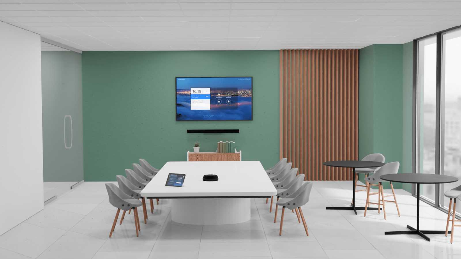 Modern conference room with a green accent wall, large screen, white table, gray chairs, and floor-to-ceiling windows providing natural light.