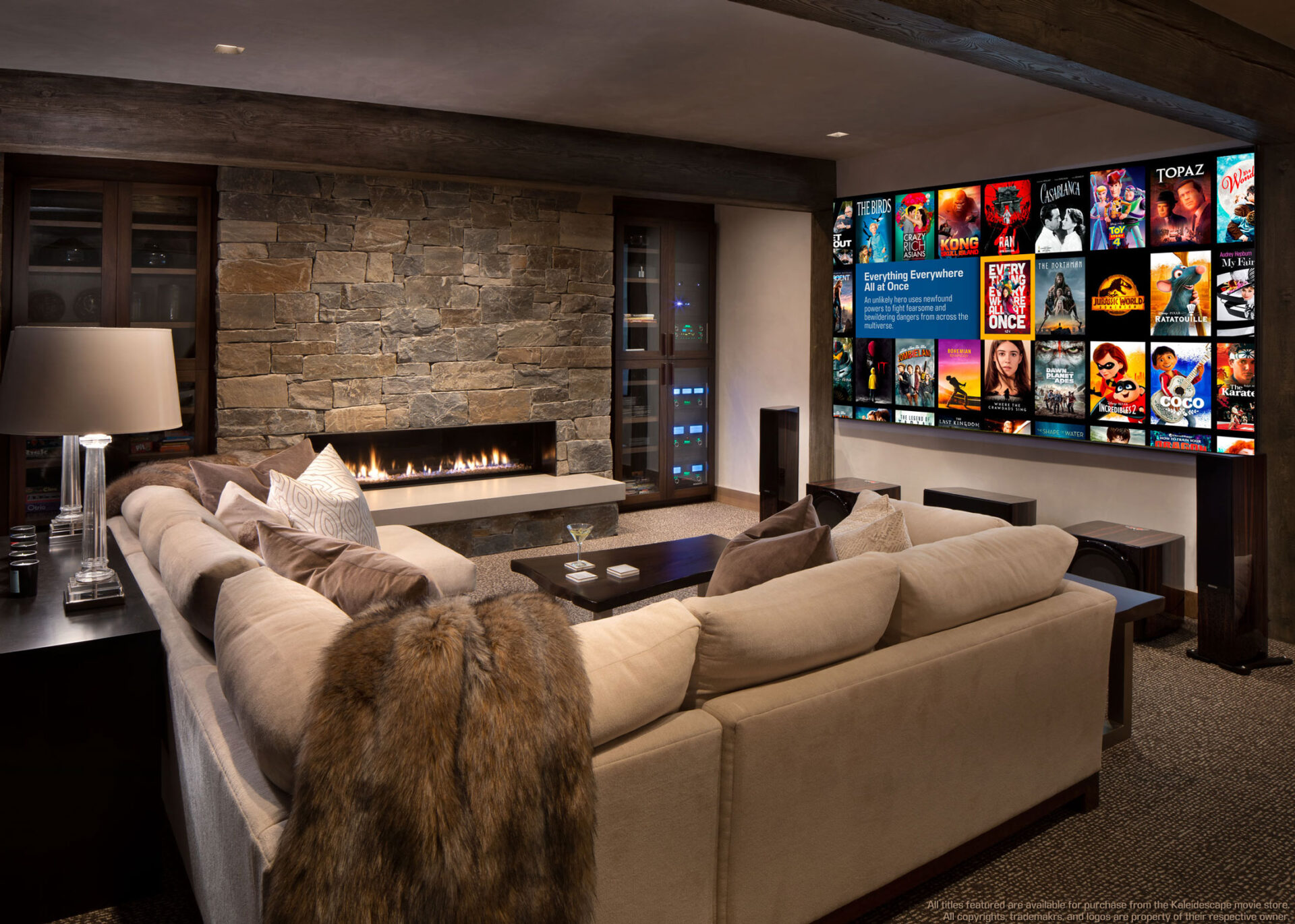 A cozy living room with a stone fireplace, large sectional sofa, wall-mounted TV displaying streaming service, and soft lighting for a relaxed atmosphere.