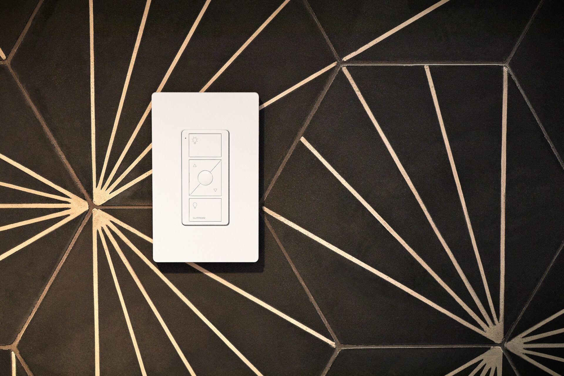 A modern light switch is mounted on a geometric-patterned wall with diagonal lines creating star-like shapes in a contemporary design.