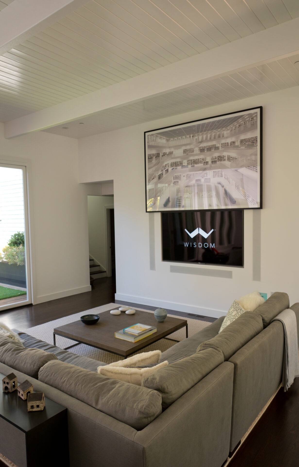 A modern living room with a gray sectional sofa, coffee table, large framed artwork, and 